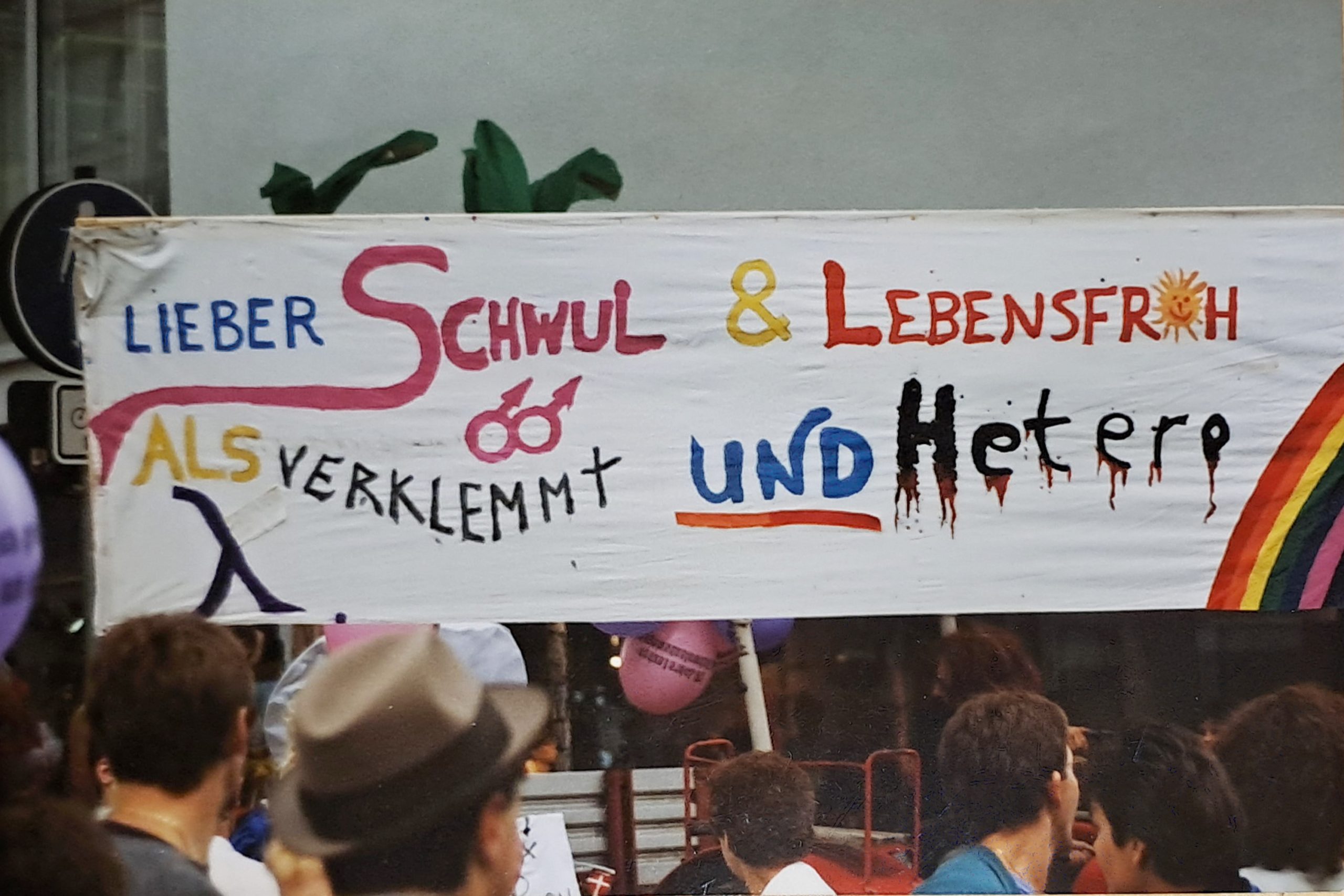Demofoto, zeigt buntes Transparent mit Aufschrift: Lieber Schwul und lebensfroh als verklemmt und hetero