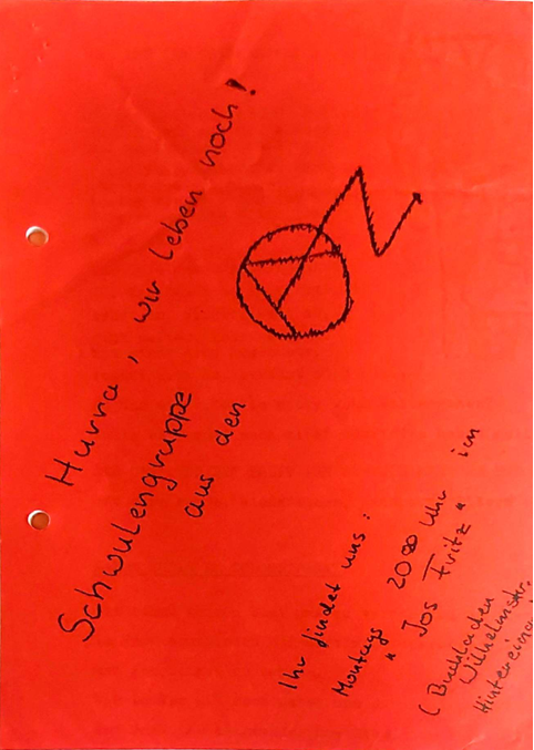 Rotes Blatt Papier, darauf steht mit schwarzem Filzstift schräg geschrieben: Hurra, wir leben noch. Schwulengruppe im AZ Ihr findet uns montags 20:00 im ,,Jos Fritz" Buchladen Wilhelmstr. Hintereingang